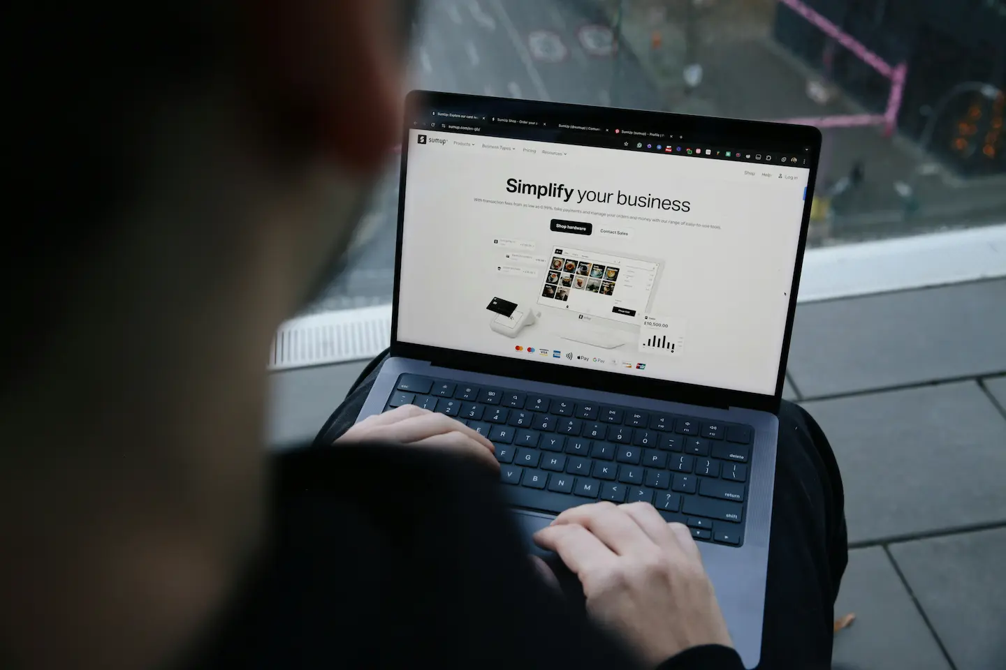 Person arbetar på en laptop med en företagshemsida på skärmen, som exempel på webbutveckling för företag och digitala affärslösningar.